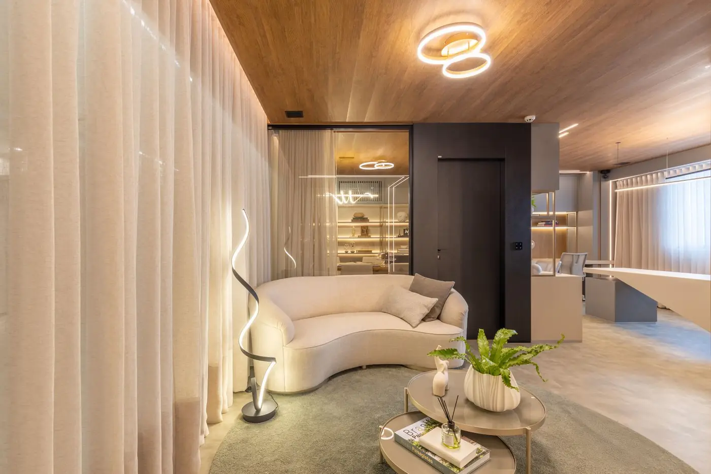 Lounge da recepção com sofá orgânico, luminária escultórica e forro em madeira